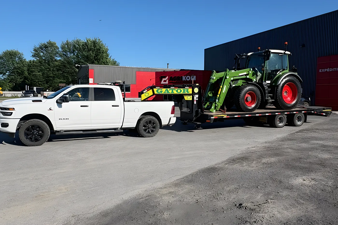 Camionnette Ram de l'Entreprise SME attelée au fardier GATOR, un tracteur Fendt neuf sanglé sur la remorque, prêt à prendre la route