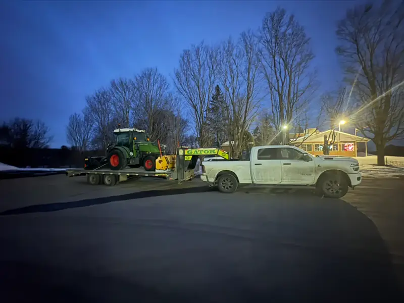 Tracteur Fendt chargé sur le fardier au crépuscule, en hiver